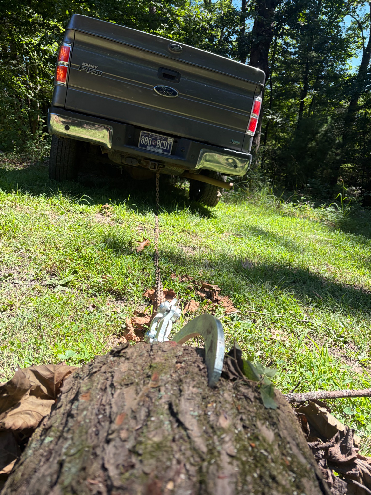 A log being moved from a wooded property with a truck